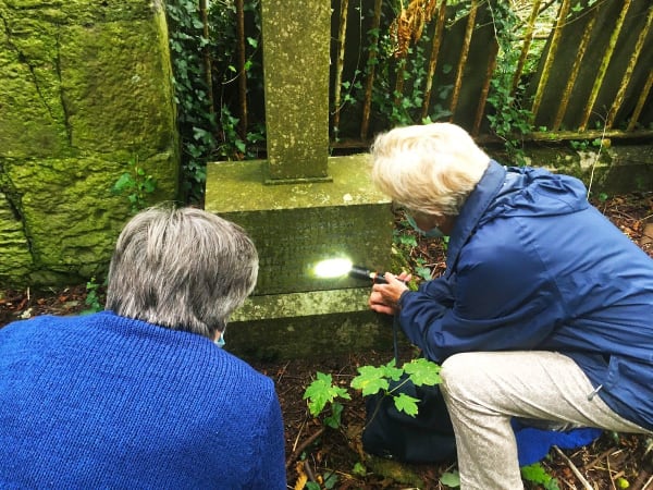 Community Members read a headstone in Aglish cemetery.